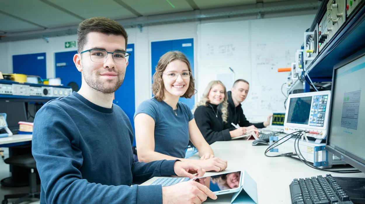 Studierende im Labor mit Computern und Geräten Studierende im Labor mit Computern und Geräten