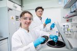 Studentin und Student im Labor in Kittel und Schutzbrille